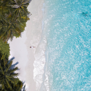Bandos Maldives Maldives Honeymoon Packages Women Lying On Beach Aerial View