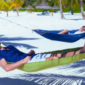 Atmosphere Kanifushi Maldives Honeymoon Packages Couples Relaxing In Hammock